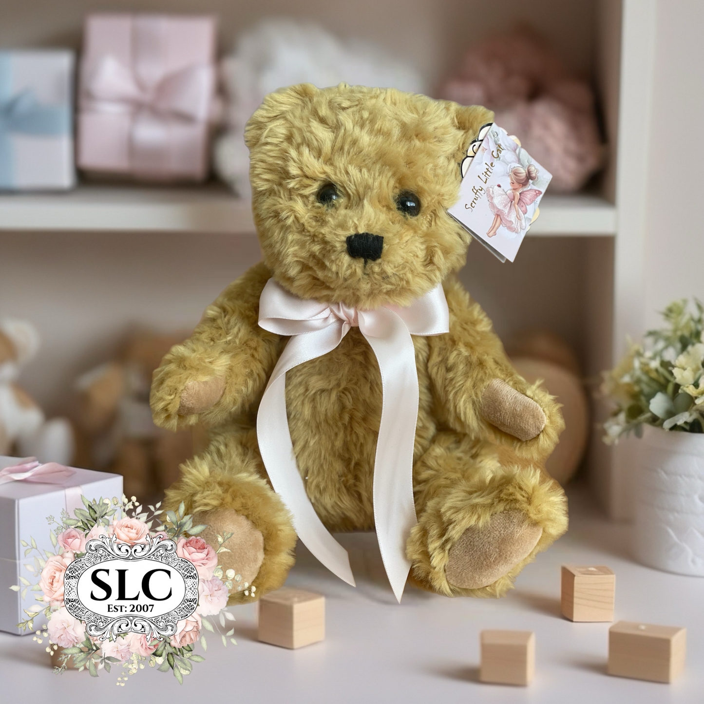 Teddy bear with a white ribbon and tag on a shelf with toys and blocks
