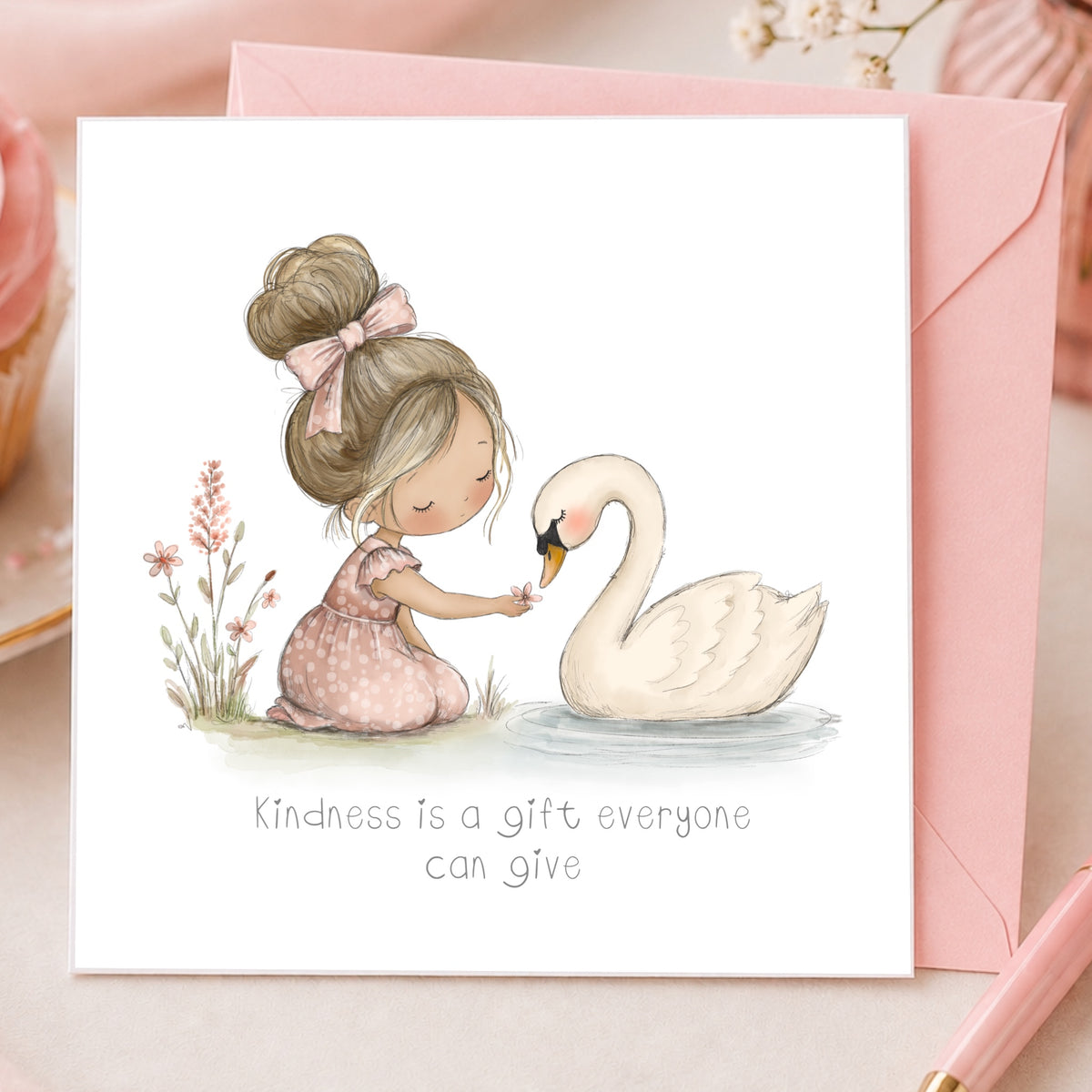 A square greeting card with a watercolor illustration of a young girl in a pink dress kneeling beside a white swan and offering something from her hand. Below the illustration, the card reads, 'Kindness is a gift everyone can give.