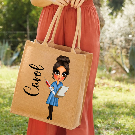 A person outdoors holding a natural jute tote bag with printed artwork of a cartoon woman in a blue nurse dress and the name 'Carol' in black script.