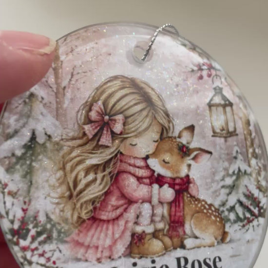 vieo showing a personalised glass tree decoraton with al illustrated pic of a little girl hugging a deer in snow scene